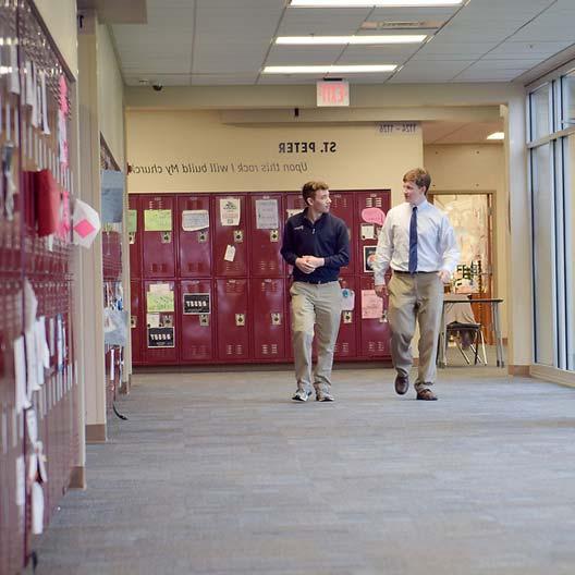 两个男人走在学校走廊上